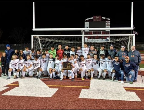 The varsity soccer team poses with the Sectional Championship plaque.